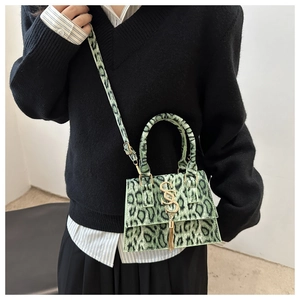 Fashionable green leopard print mini crossbody bag with gold S-logo and fringe detail