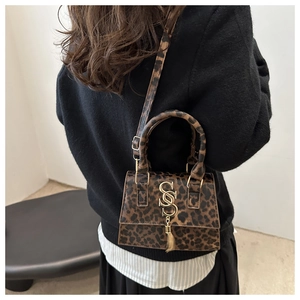 Detail of leopard print handbag with gold metal S-pendant and fine horsehair texture