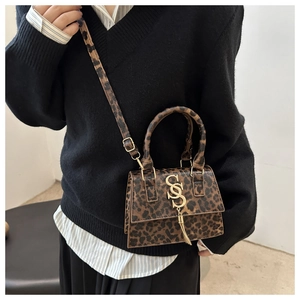 Close-up of leopard print mini square bag featuring gold logo and stylish tassel detail
