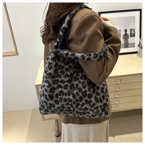 Détail d'un grand cabas en peluche à motif léopard porté par un mannequin en intérieur