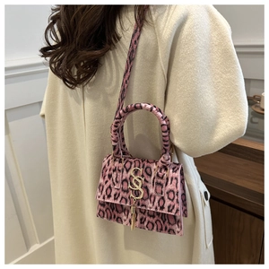 Detail of pink leopard print crossbody bag with gold metal logo and fringe tassel
