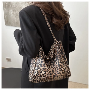 Detailed back view of a large leopard print canvas tote bag on a model's shoulder