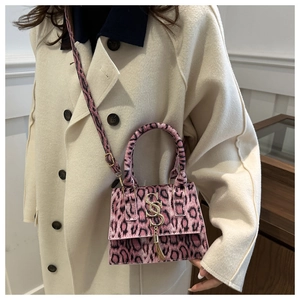 Pink leopard print crossbody bag detail shown with adjustable shoulder strap on model