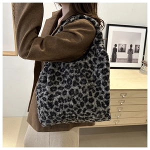 Détail d'un sac cabas en peluche à motif léopard porté par un mannequin pour l'hiver