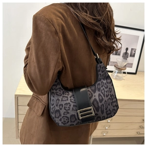 Gros plan du sac hobo à motif léopard avec boucle dorée sur l'épaule d'un mannequin