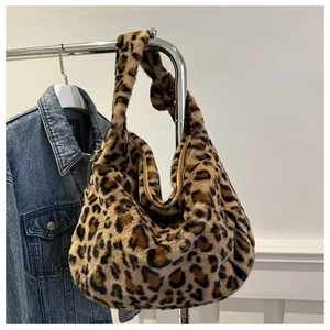 Détail d'un sac hobo en peluche à imprimé léopard avec fermeture éclair sur un rack
