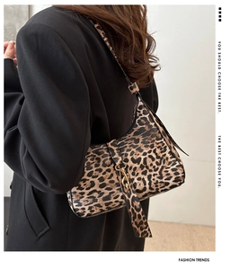 Sac hobo imprimé léopard avec boucle dorée porté à l'épaule pour un style chic et sobre