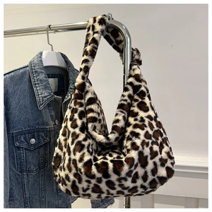 Détail d'un sac hobo en peluche à motif léopard suspendu à un cintre métallique