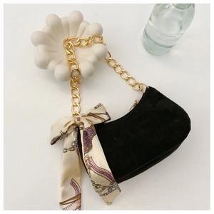 Détail du sac demi-lune en daim noir avec chaîne dorée et décor de foulard en soie