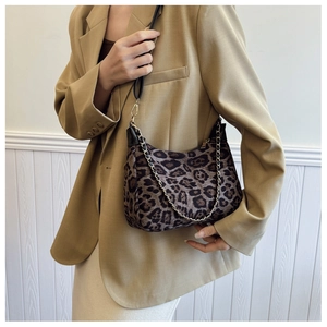 Détail du sac léopard avec chaîne dorée et fine bandoulière noire sur veste beige