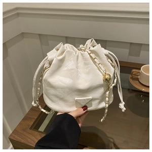 Detail of white leather drawstring bucket bag with gold chain strap and FASHION logo