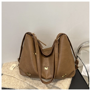 Detail of brown PU leather hobo bag with vintage golden butterfly metal buckle ornaments