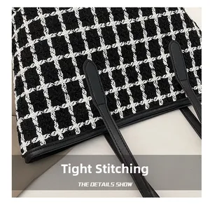 Close-up of precise stitching and black leather strap on a tweed checkered tote bag