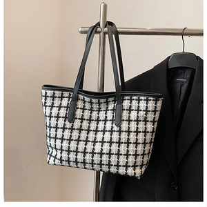 Detail of checkered tote bag made of thick tweed fabric with premium leather straps