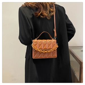 Vue portée du sac bandoulière marron caramel avec grosse chaîne et texture matelassée