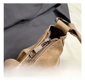 Detail of silver metal zipper and brown litchi pattern leather on chic crescent bag