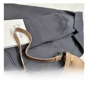 Detail view of the brown faux leather handbag strap and vintage metal hardware buckle