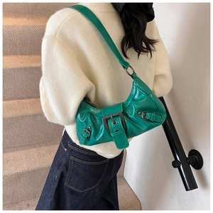 Detail of a bright green ruched shoulder bag with silver buckle worn by a model