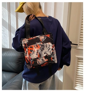 Detail of nylon messenger bag featuring orange graffiti prints and double buckle closures