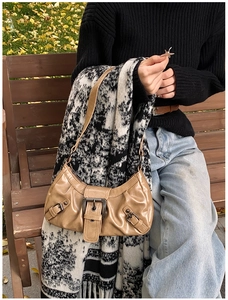 Detail of khaki crescent shoulder bag with vintage metal buckle and pleated PU leather finish