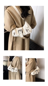 Close-up of creamy white pleated leather texture and metallic buckles on underarm bag