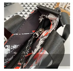 Detail of smooth metal zipper and black nylon strap on graffiti print bag