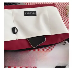 Dettaglio borsa in tela con tasca laterale per smartphone e anello a D in plastica