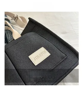 Macro shot of minimalist canvas bag showing JINGPIN leather label and fabric texture