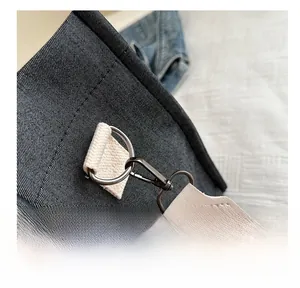 Detailed close-up of dark denim tote bag with heavy-duty metal hook and canvas strap