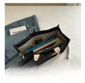 Interior view of large black canvas tote bag showing roomy pockets and daily essentials