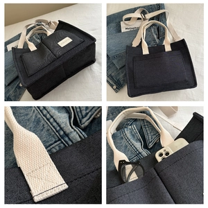 Detail view of denim tote bag with dual pockets and reinforced canvas handles