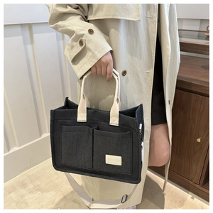 Detail of grey fabric tote bag with JINGPIN label and adjustable shoulder strap