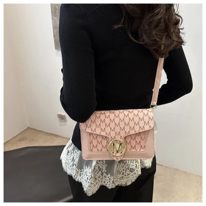 Borsa a tracolla rosa con stampa M e fibbia dorata indossata da una modella