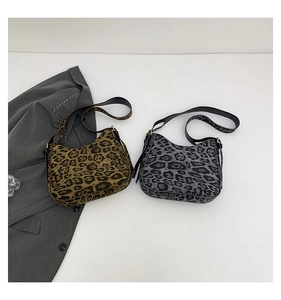 Flat lay of brown and grey leopard print hobo bags with black leather straps