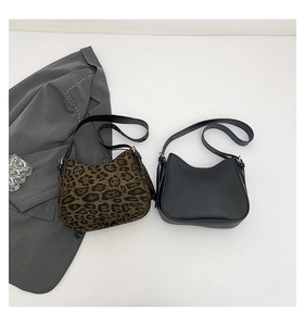 Detail of leopard print and black leather shoulder bags with gold metal buckles