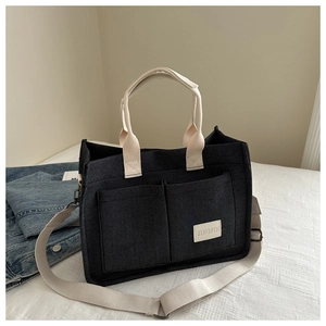 Retro black canvas tote bag with multiple pockets and adjustable shoulder strap