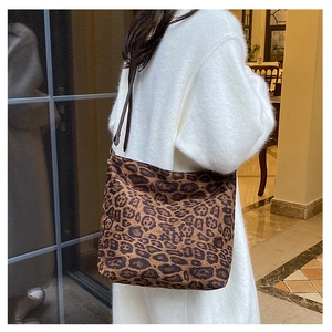 Detailed view of the large leopard print tote bag with brown straps worn on shoulder