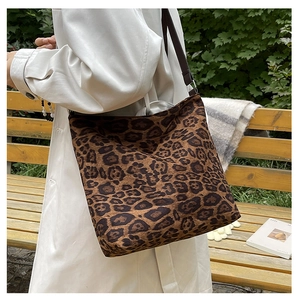 Detail of a large leopard print tote bag in faux suede fabric with wide shoulder straps