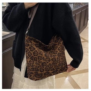 Detail of leopard print hobo bag with dark brown strap in cozy indoor setting