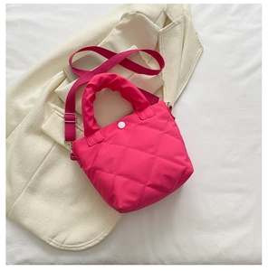 Detail of fuchsia quilted bucket bag with padded handles and wide shoulder strap
