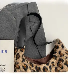 Detail of leopard print faux fur handbag featuring soft plush texture and black handles