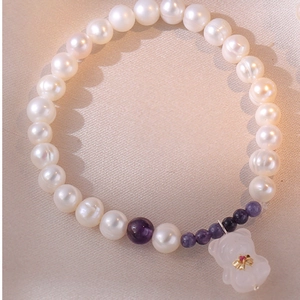 Détail macro du bracelet en perles S925 avec cristaux violets et pendentif petit ours