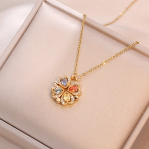 Detail of four-leaf clover heart pendant with colorful gemstones and gold chain link
