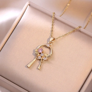 Elegant gold necklace with pink stone pendant on champagne satin jewelry box display