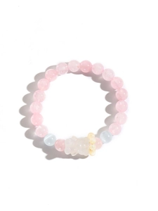 Detailansicht eines rosa Perlenarmbands mit einem süßen weißen Harz-Bärenanhänger
