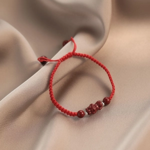 Handwoven red rope bracelet with cinnabar PiXiu charm and silver beads for good luck
