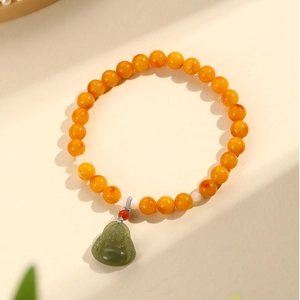 Natural amber beads bracelet featuring a green jade Buddha pendant and warm orange tones