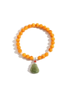 Detail of amber bead bracelet with green jade Maitreya Buddha pendant and red accent bead