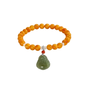 Handmade beaded bracelet with amber-colored beads and a green jade-style Buddha pendant