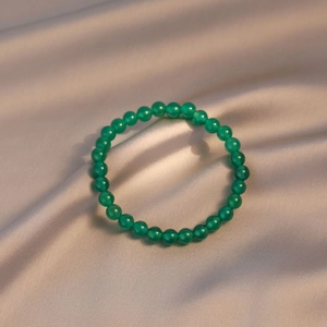 Elegant green natural agate beaded bracelet on luxurious satin silk background